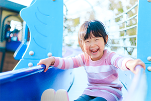 滑り台で遊ぶ少女